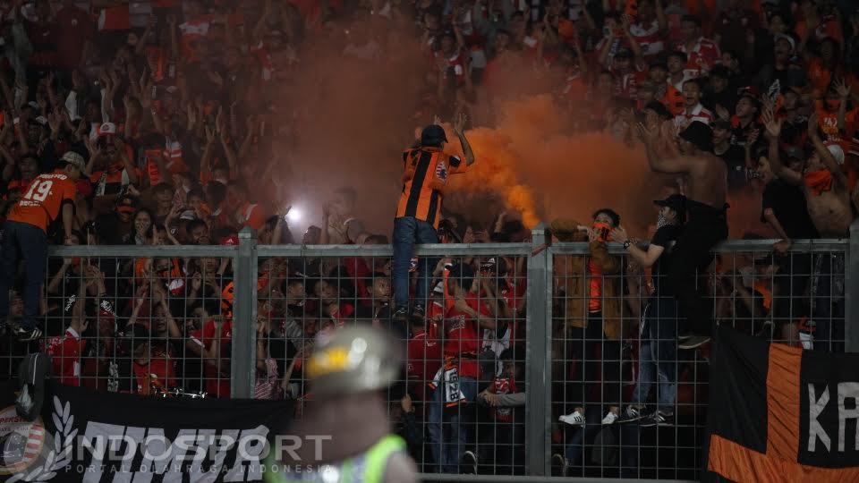 Oknum The Jakmania menyalakan flare.